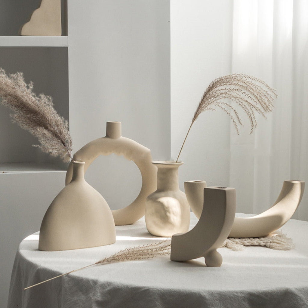 Set of modern ceramic vases on a table with dried plants
