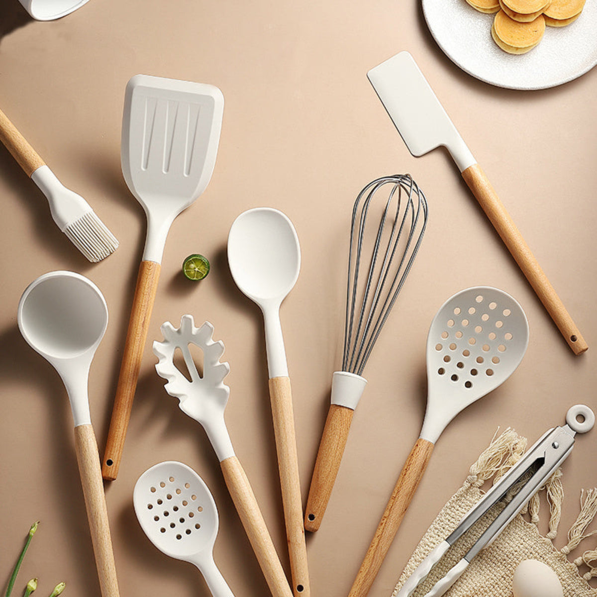 Set of kitchen utensils with wooden handles on a beige background