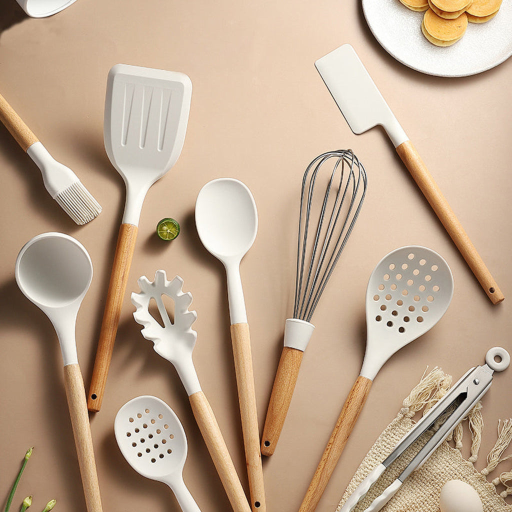 Set of kitchen utensils with wooden handles on a beige background