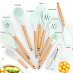 Set of kitchen utensils with wooden handles and green silicone heads on a white background.