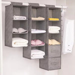 Gray hanging shelf with folded clothes on a white background